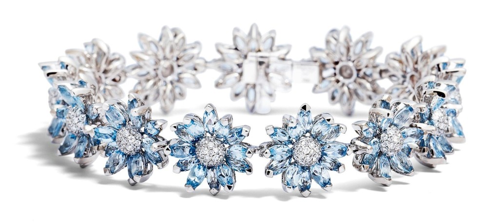 Individually set marquise stones form the petals of the daisy flower from brilliant cut diamonds and aquamarines. 