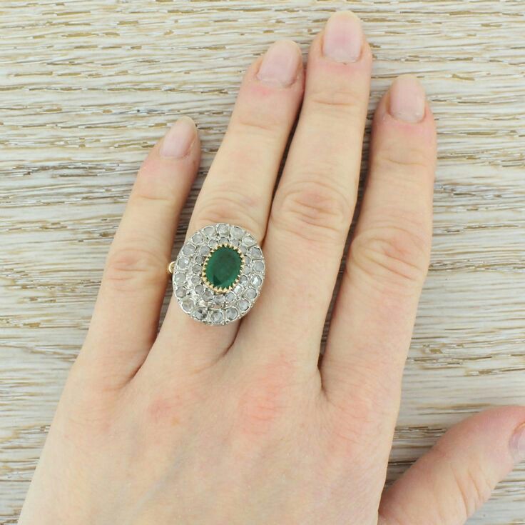 So much detail in this awesome mid century cocktail ring. The central emerald is a striking grassy green, and sits within an impressive two layered cluster of rose cut diamonds; thirty-six in total. The detailed etched gallery leads to a carved leaf trip-split shoulders on a substantial D-shaped shank.