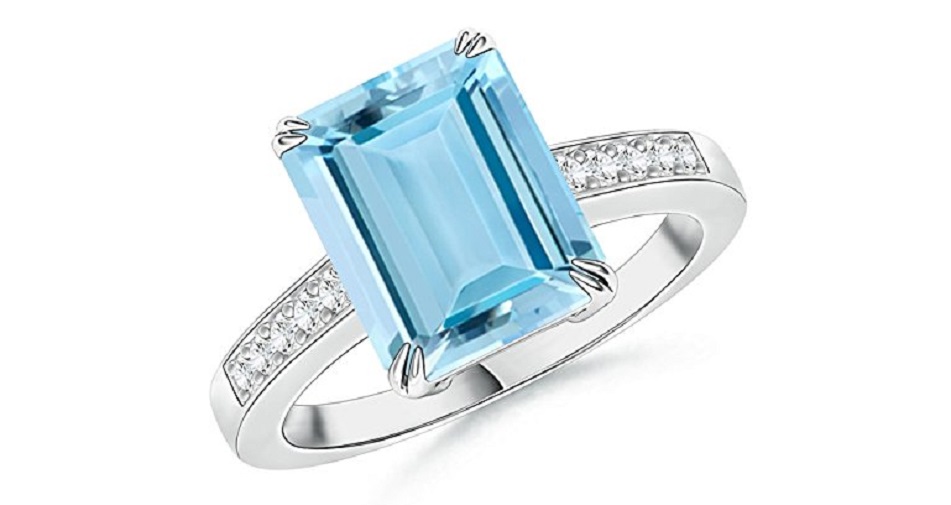 The emerald-cut aquamarine is held in a double claw prong setting and has a serene sea blue hue. Shimmering pave set diamonds embellish the shank and accentuate the sparkling aquamarine. This aquamarine cocktail ring is crafted in 14k white gold.