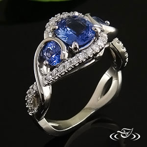 Sapphire ring with cushion cut 1.12ct unheated sapphire & 2 round 4mm (.59ctw) sapphires. Surrounded by Micro-pave set diamonds