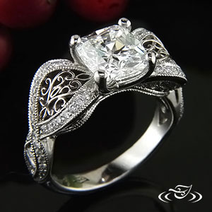 Organic sweep shank ring with bead set diamonds, hand fabricated filigree in openings, and channel set side stones with criss cross pattern.