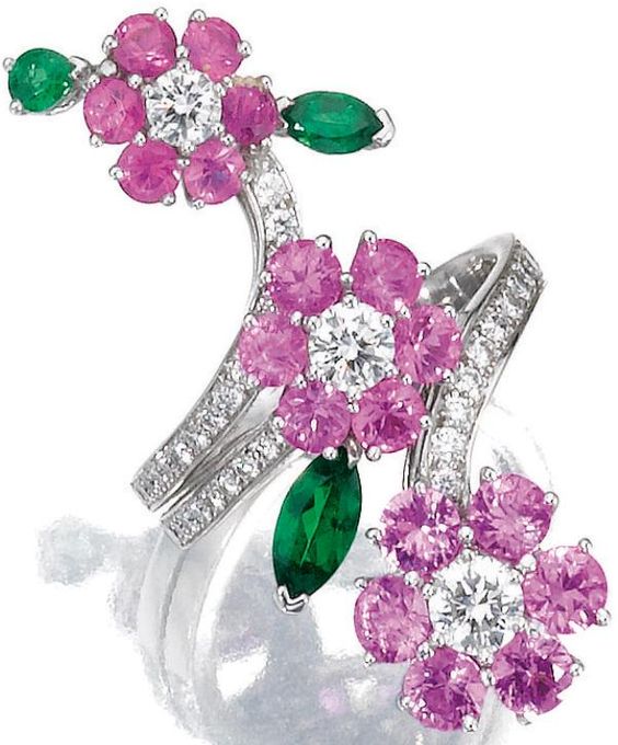 Gem-set and diamond ring, Van Cleef & Arpels. Designed as three flowers set with circular-cut pink sapphires, pear- and marquise-shaped garnets, highlighted with brilliant-cut diamonds, mounted in white gold, size 56, signed Van Cleef & Arpels and numbered, French assay and partial maker's marks, accompanied by fitted case signed Van Cleef & Arpels.